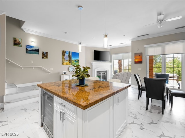 30 Via Vasari Unit 103, Henderson, NV 89011 - kitchen with wine cooler, light marble finish floors, ornamental molding, a center island, and a ceiling fan