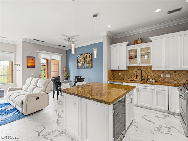 30 Via Vasari Unit 103, Henderson, NV 89011 - kitchen with light marble finish flooring, beverage cooler, open floor plan, white cabinetry, and glass insert cabinets