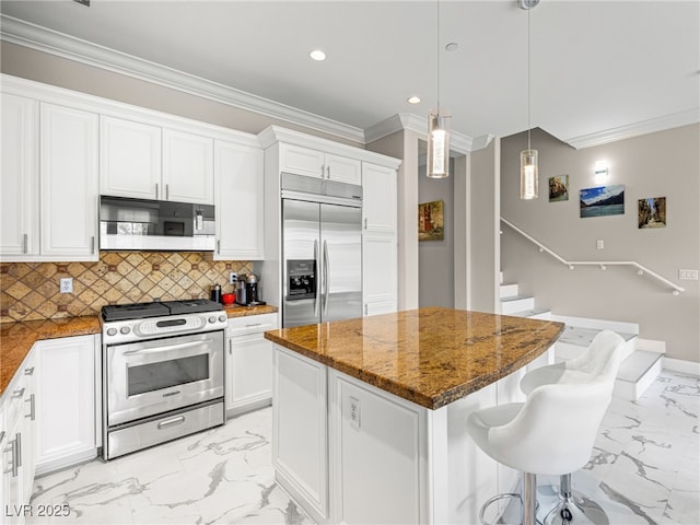 30 Via Vasari Unit 103, Henderson, NV 89011 - kitchen featuring stainless steel appliances, light marble finish floors, ornamental molding, dark stone countertops, and a center island