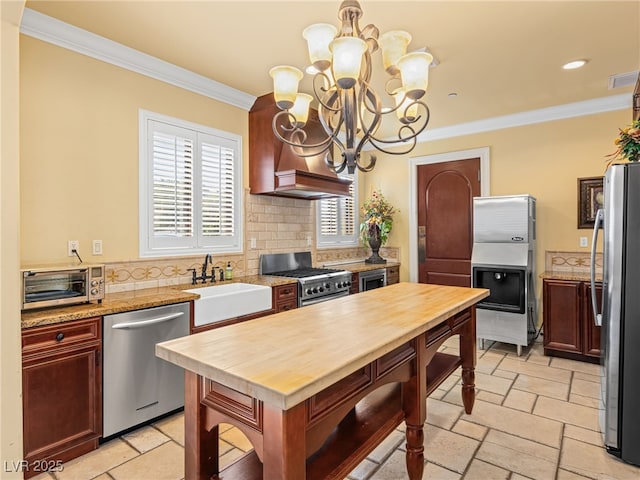 30 Via Vasari Unit 103, Henderson, NV 89011 - kitchen featuring stainless steel appliances, a sink, a chandelier, ornamental molding, and butcher block counters