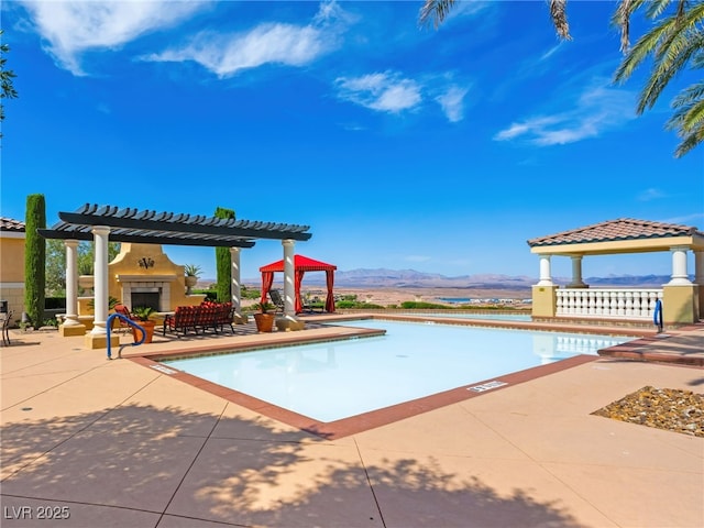 30 Via Vasari Unit 103, Henderson, NV 89011 - community pool with a gazebo, a mountain view, a pergola, a patio area, and a tiled fireplace