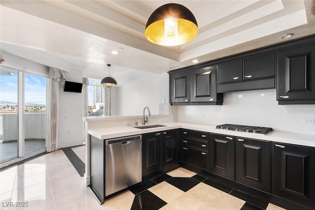 2777 Paradise Rd Unit 303, Las Vegas, NV 89109 - kitchen featuring stainless steel appliances, dark cabinetry, a tray ceiling, a sink, and light countertops