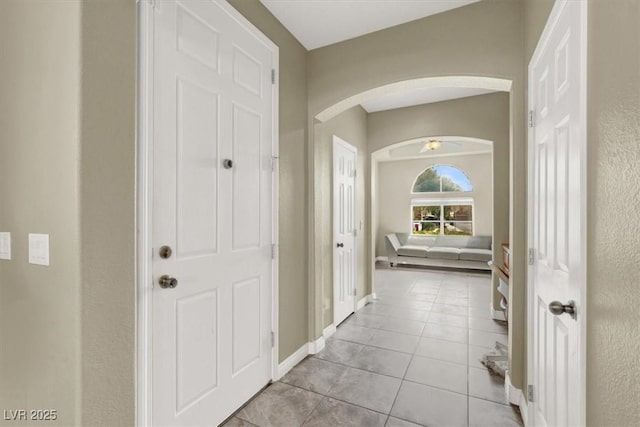 8015 Maple Park St, Las Vegas, NV 89131 - hallway with arched walkways, light tile patterned floors, and baseboards