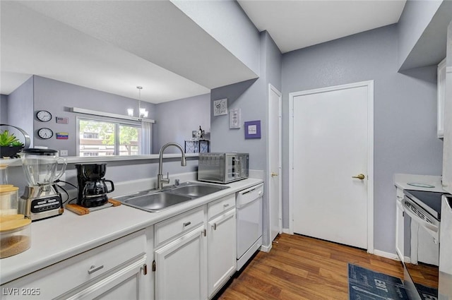 6650 W Warm Springs Rd Unit 1083, Las Vegas, NV 89118 - kitchen featuring white appliances, a sink, wood finished floors, white cabinetry, and light countertops