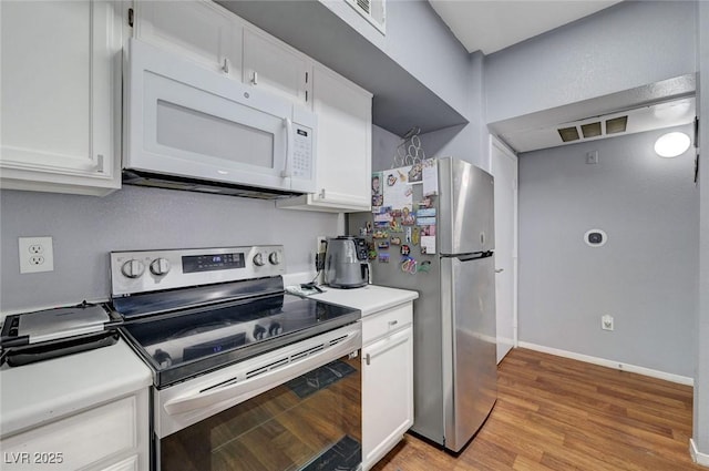 6650 W Warm Springs Rd Unit 1083, Las Vegas, NV 89118 - kitchen with appliances with stainless steel finishes, light countertops, white cabinetry, light wood finished floors, and baseboards