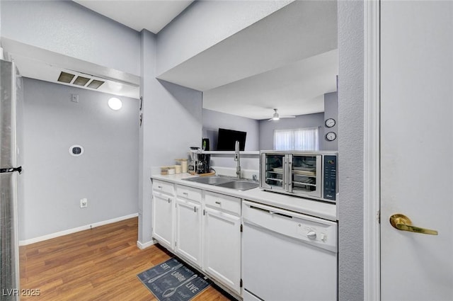 6650 W Warm Springs Rd Unit 1083, Las Vegas, NV 89118 - kitchen with dishwasher, a sink, white cabinetry, light wood finished floors, and ceiling fan