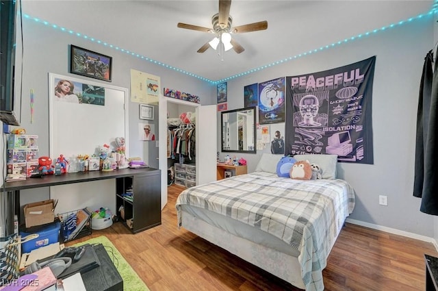 6650 W Warm Springs Rd Unit 1083, Las Vegas, NV 89118 - bedroom featuring wood finished floors, a walk in closet, baseboards, a closet, and a ceiling fan