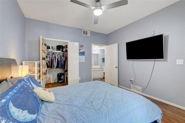 6650 W Warm Springs Rd Unit 1083, Las Vegas, NV 89118 - bedroom featuring wood finished floors, a walk in closet, baseboards, a closet, and ensuite bathroom