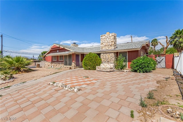 812 Pyramid Dr, Las Vegas, NV 89107 - view of front facade featuring a chimney, a patio, a gate, and stone siding