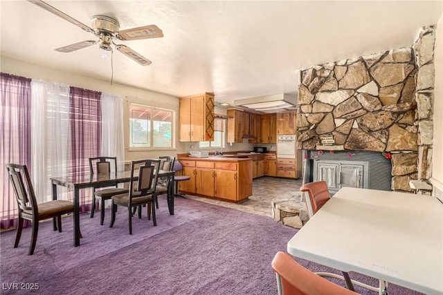 812 Pyramid Dr, Las Vegas, NV 89107 - dining area with light colored carpet, a ceiling fan, and a fireplace