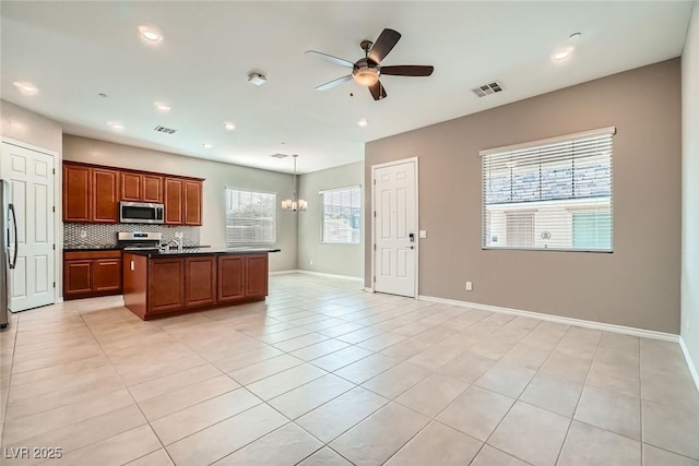 208 Coltrane Canyon Ave, Henderson, NV 89011 - kitchen featuring stainless steel appliances, dark countertops, a ceiling fan, a center island, and tasteful backsplash