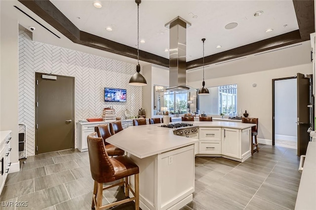 208 Coltrane Canyon Ave, Henderson, NV 89011 - kitchen with a large island, light countertops, stainless steel gas stovetop, white cabinetry, and an accent wall