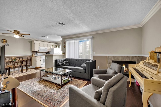 3150 Soft Breezes Dr Unit 1040, Las Vegas, NV 89128 - living area featuring ornamental molding, ceiling fan, dark wood-type flooring, a textured ceiling, and a brick fireplace