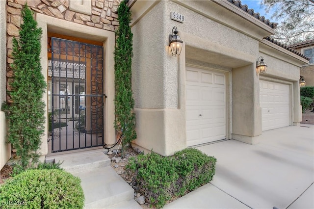 9349 Olympia Falls Ave, Las Vegas, NV 89149 - entrance to property featuring stone siding, a garage, concrete driveway, and stucco siding