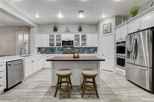 9349 Olympia Falls Ave, Las Vegas, NV 89149 - kitchen with stainless steel appliances, wooden counters, a sink, white cabinetry, and recessed lighting