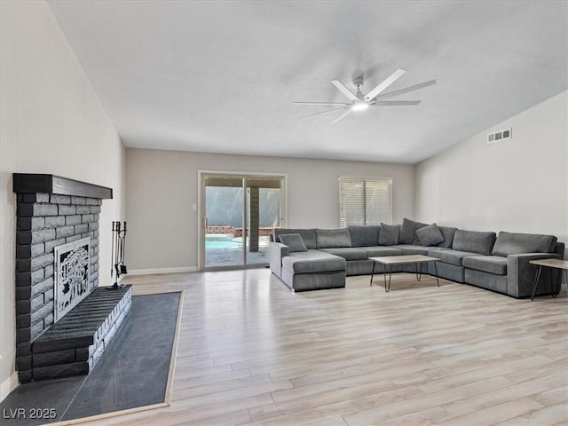 6436 Vinecrest Ave, Las Vegas, NV 89108 - living room with a ceiling fan, light wood-style floors, and a brick fireplace
