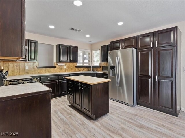 6436 Vinecrest Ave, Las Vegas, NV 89108 - kitchen featuring stainless steel appliances, light wood-style floors, tasteful backsplash, recessed lighting, and a center island