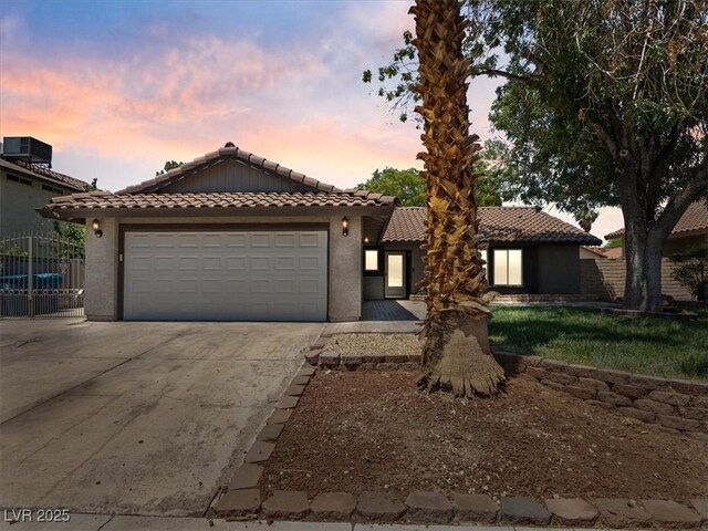 6436 Vinecrest Ave, Las Vegas, NV 89108 - mediterranean / spanish-style home with a tiled roof, driveway, an attached garage, and stucco siding