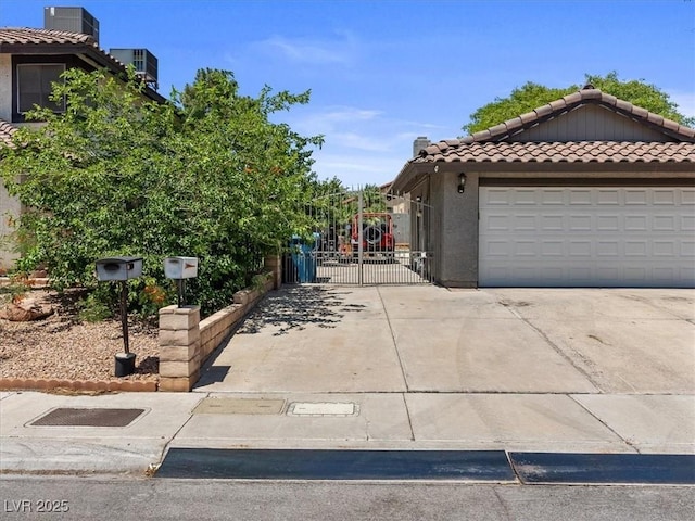 6436 Vinecrest Ave, Las Vegas, NV 89108 - view of side of property featuring a gate, a tile roof, driveway, stucco siding, and a garage