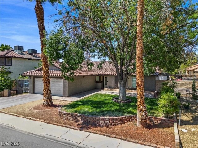 6436 Vinecrest Ave, Las Vegas, NV 89108 - view of front facade with concrete driveway, a tile roof, stucco siding, and an attached garage