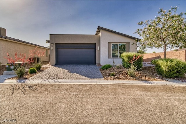 5091 E Beacon Ridge Dr, Pahrump, NV 89061 - view of front facade featuring decorative driveway, an attached garage, and stucco siding