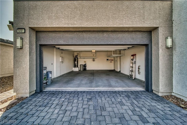 5091 E Beacon Ridge Dr, Pahrump, NV 89061 - garage with a central vacuum unit and decorative driveway