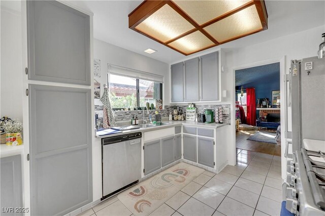 4629 Denwood Dr, Las Vegas, NV 89147 - kitchen featuring appliances with stainless steel finishes, a sink, light tile patterned floors, tasteful backsplash, and gray cabinetry