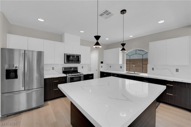 9604 Stoney Mesa Ct, Las Vegas, NV 89139 - kitchen featuring appliances with stainless steel finishes, a sink, modern cabinets, light wood finished floors, and recessed lighting