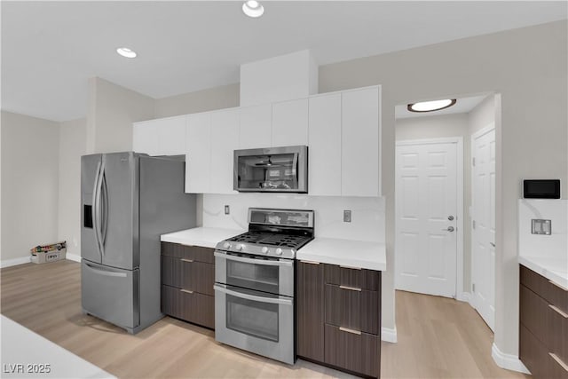 9604 Stoney Mesa Ct, Las Vegas, NV 89139 - kitchen featuring stainless steel appliances, light wood finished floors, light countertops, modern cabinets, and recessed lighting