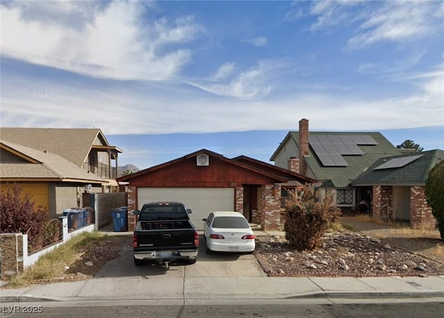 653 Lineshack Ln, Las Vegas, NV 89110 - view of front of home with a garage, concrete driveway, roof mounted solar panels, and brick siding