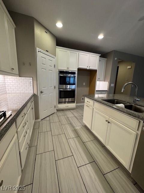 4108 Fairywren Dr, North Las Vegas, NV 89031 - kitchen featuring a sink, stainless steel double oven, backsplash, white cabinets, and recessed lighting