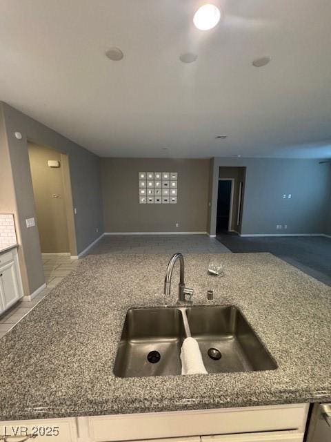 4108 Fairywren Dr, North Las Vegas, NV 89031 - kitchen featuring a sink, white cabinetry, baseboards, and open floor plan