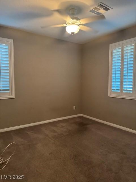 4108 Fairywren Dr, North Las Vegas, NV 89031 - unfurnished room with dark carpet, baseboards, ceiling fan, and healthy amount of natural light