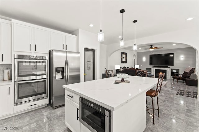 366 Rancho La Costa St, Las Vegas, NV 89138 - kitchen featuring appliances with stainless steel finishes, arched walkways, light marble finish floors, and recessed lighting