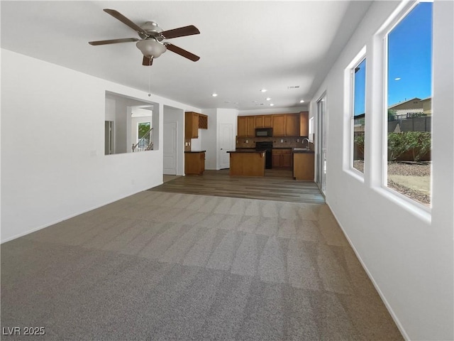 8253 Pearl Oasis Ct, Las Vegas, NV 89139 - unfurnished living room featuring ceiling fan, light colored carpet, recessed lighting, baseboards, and a sink