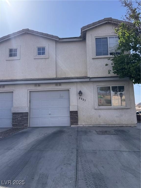 2025 Cary Grant Ct, Las Vegas, NV 89142 - view of property featuring stucco siding, stone siding, driveway, and an attached garage