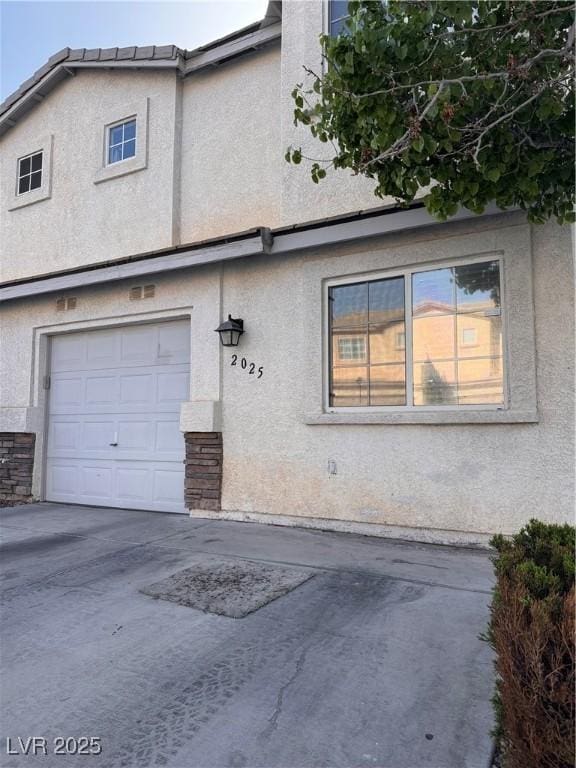 2025 Cary Grant Ct, Las Vegas, NV 89142 - view of side of home with stucco siding, an attached garage, and concrete driveway