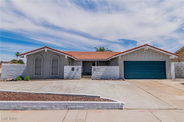 4813 Plata Del Sol, Las Vegas, NV 89121 - view of front facade with a tile roof, an attached garage, driveway, stucco siding, and a gate