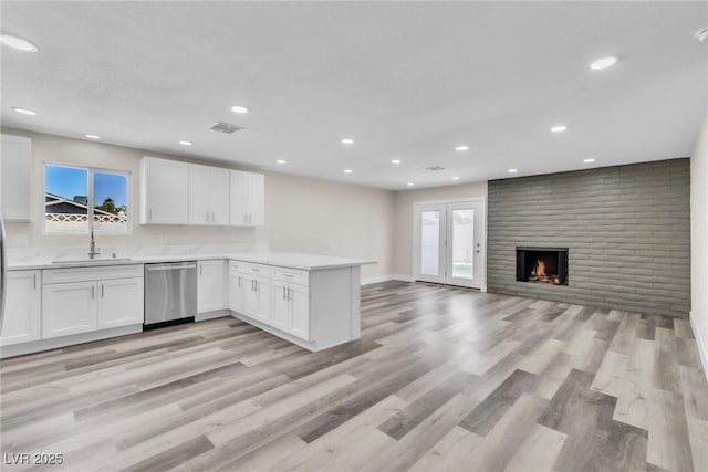 4813 Plata Del Sol, Las Vegas, NV 89121 - kitchen featuring stainless steel dishwasher, a sink, a peninsula, white cabinetry, and plenty of natural light