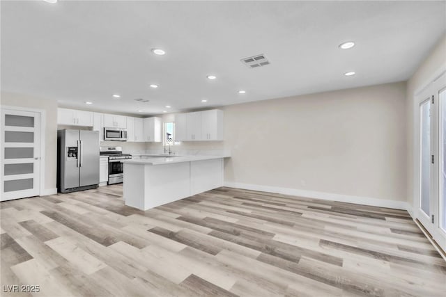 4813 Plata Del Sol, Las Vegas, NV 89121 - kitchen featuring appliances with stainless steel finishes, recessed lighting, a peninsula, white cabinetry, and light countertops