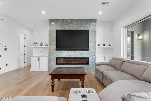 2309 Prometheus Ct, Henderson, NV 89074 - living area with built in features, light wood-style flooring, a high end fireplace, baseboards, and recessed lighting