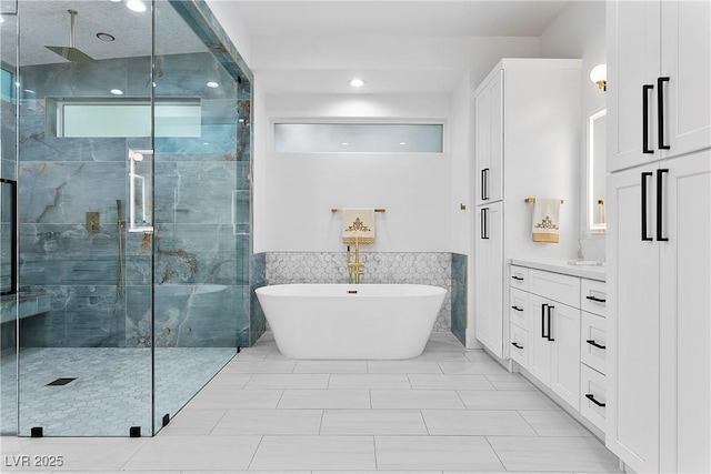 2309 Prometheus Ct, Henderson, NV 89074 - bathroom with a shower stall, a soaking tub, vanity, a wainscoted wall, and tile walls