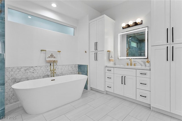 2309 Prometheus Ct, Henderson, NV 89074 - bathroom featuring a soaking tub, vanity, tile walls, wainscoting, and recessed lighting