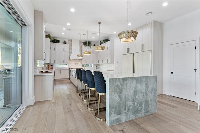 2309 Prometheus Ct, Henderson, NV 89074 - kitchen with a sink, custom exhaust hood, light wood-style floors, a large island, and recessed lighting
