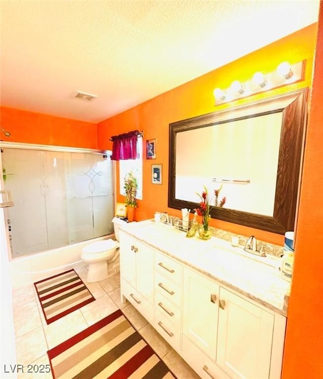 8156 Blue Hope Diamond Ln, Las Vegas, NV 89139 - full bath with toilet, double vanity, tile patterned floors, bath / shower combo with glass door, and a textured ceiling