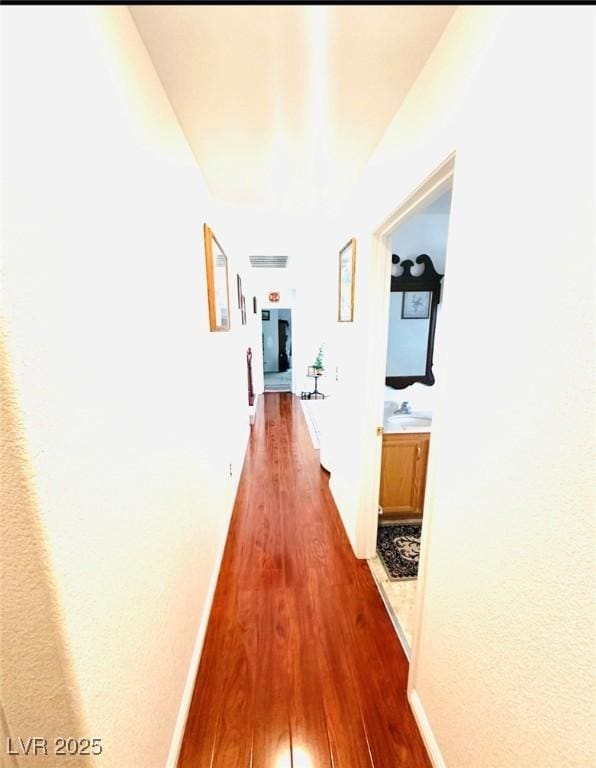 8156 Blue Hope Diamond Ln, Las Vegas, NV 89139 - hallway with dark wood-style flooring, a sink, and baseboards