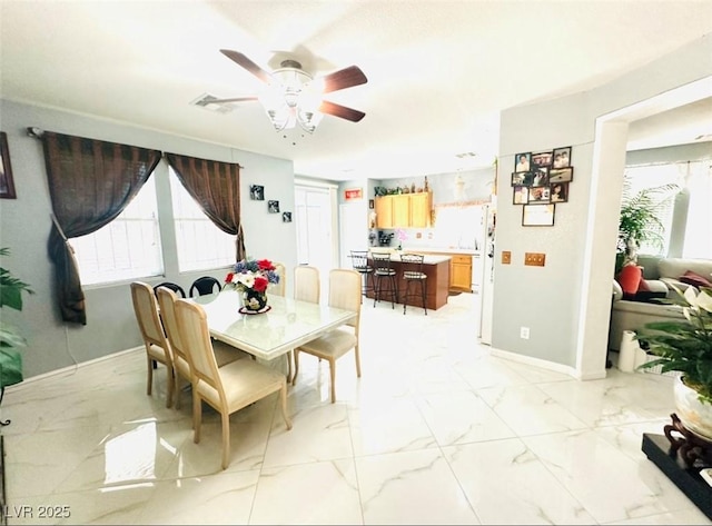 8156 Blue Hope Diamond Ln, Las Vegas, NV 89139 - dining space featuring healthy amount of natural light, light marble finish floors, a ceiling fan, and baseboards