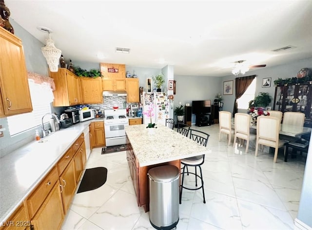 8156 Blue Hope Diamond Ln, Las Vegas, NV 89139 - kitchen with white appliances, a sink, a kitchen bar, and light marble finish flooring