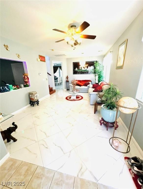 8156 Blue Hope Diamond Ln, Las Vegas, NV 89139 - living area with ceiling fan, plenty of natural light, marble finish flooring, and baseboards