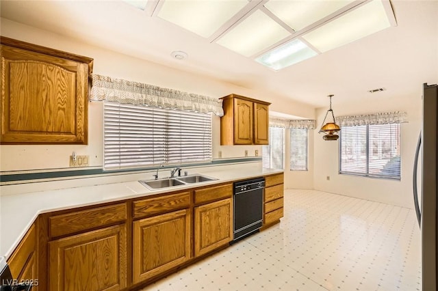 3104 Hayden Ct, Las Vegas, NV 89134 - kitchen with dishwasher, freestanding refrigerator, brown cabinets, light countertops, and hanging light fixtures